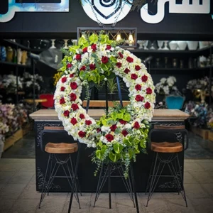 تاج گل تبریک لاکچری با رز قرمز و گل‌های سفید ژورنالی